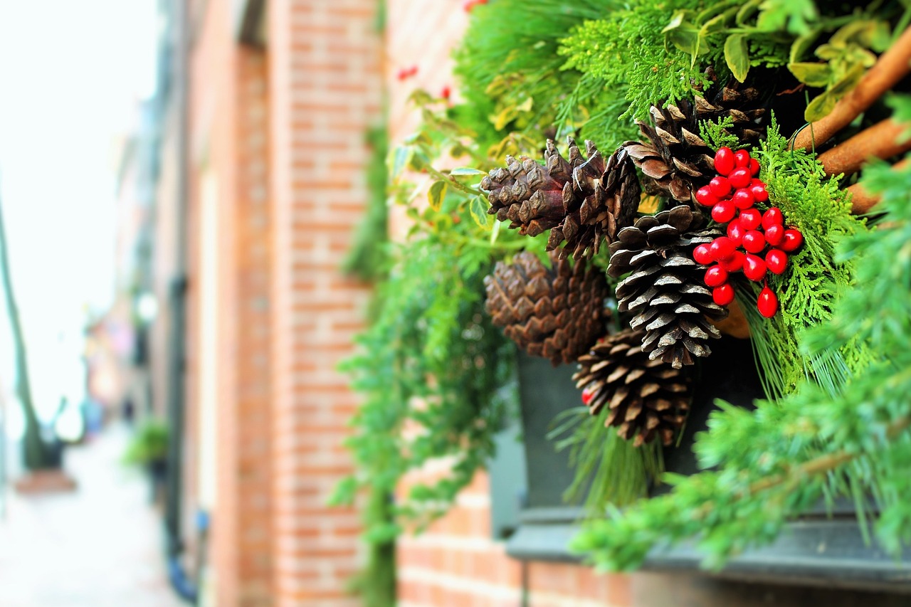 Festive evergreen and pinecone decorations on a brick wall