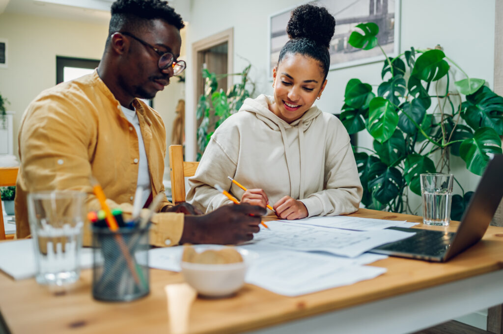 Couple completing paperwork to refinance their mortgage loan