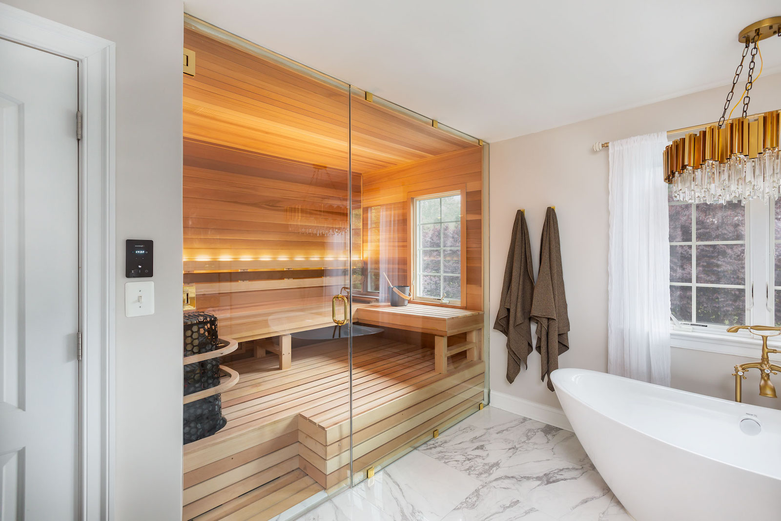 Home sauna in a large bathroom with freestanding tub