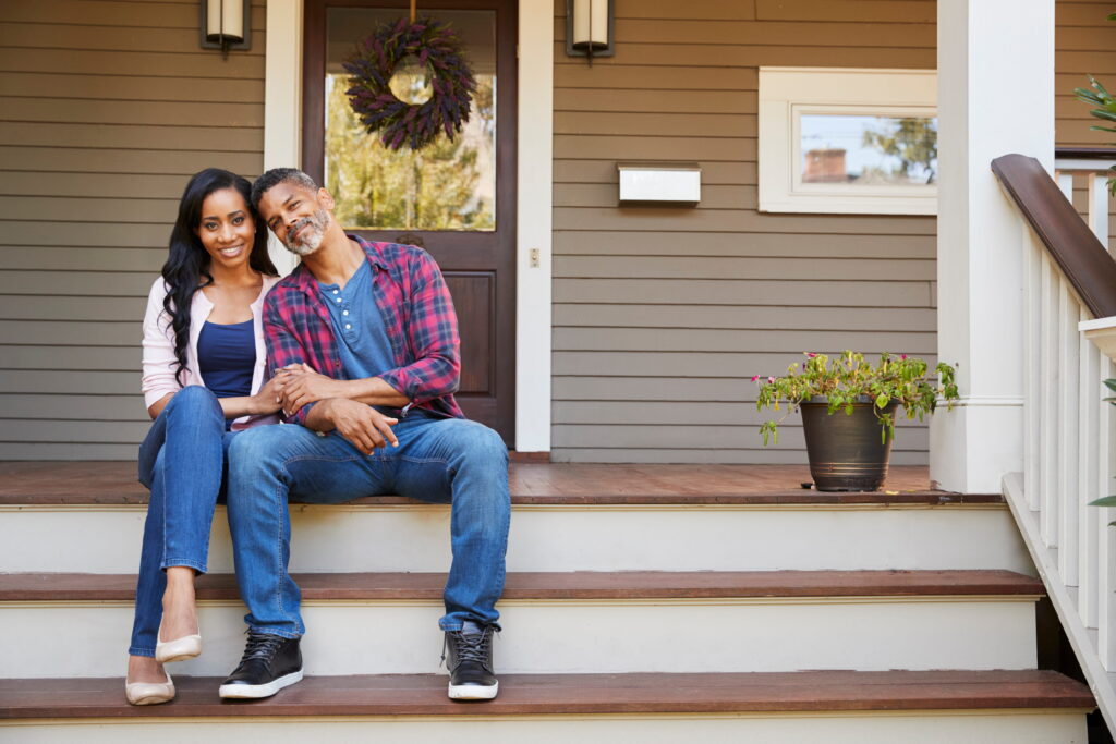 Couple sitting on the porch of their new home