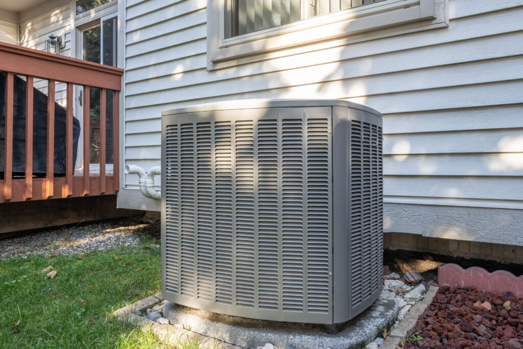 Air conditioner condenser unit on the outside of a home