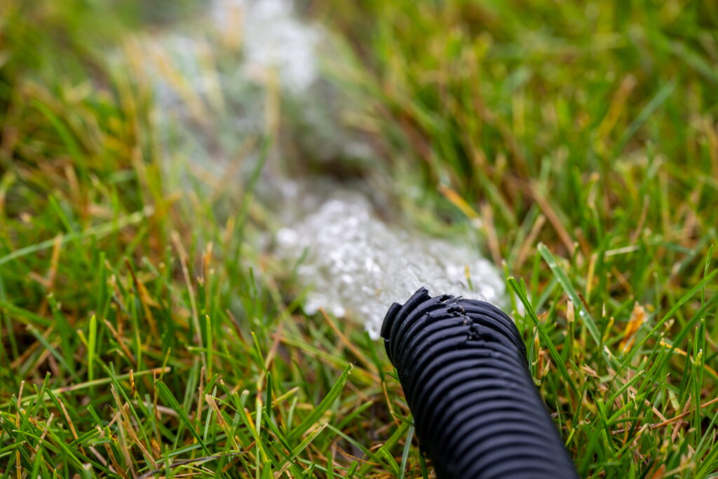 Home sump pump with water rushing into the grass