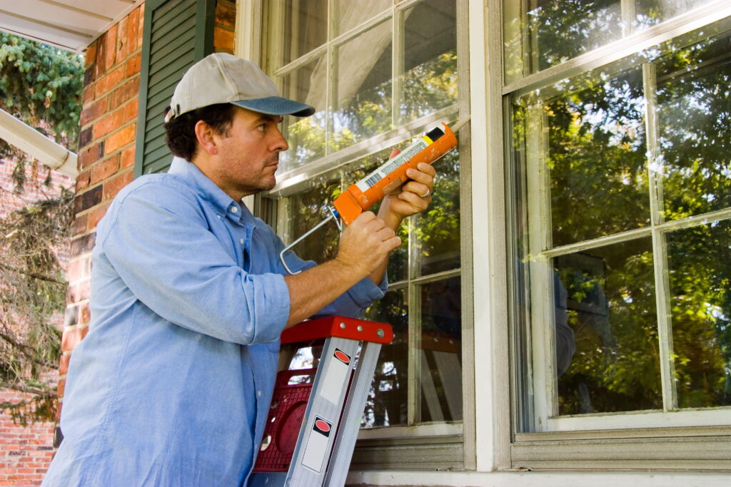 Man caulking a drafty window