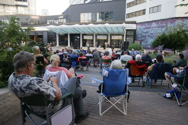 People gathered in the Ped Mall in Iowa City, Iowa watching a performance during the Friday Night Concert Series