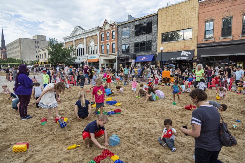 Children playing in the sand at the Iowa City Block Party