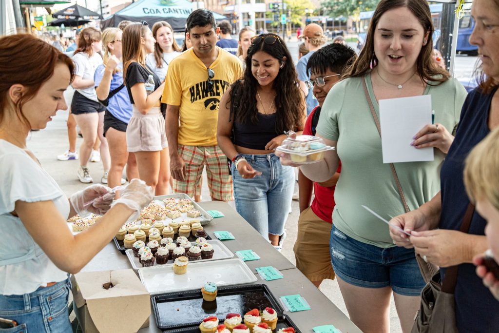 People tasting food samples at the Taste of Iowa City